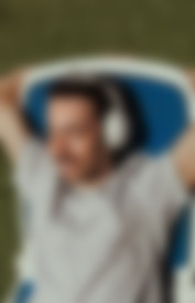 Ein entspannter Mann mit REAL BLUE NC 3 Kopfhörern genießt die Natur.