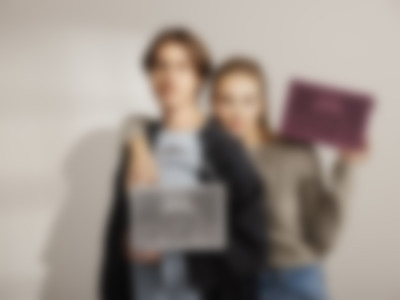 Twee modellen poseren samen, elk met een MYND bluetooth speaker, die een warm wit en wilde bessen kleurenpalet toont.