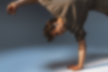 A person performs a handstand while wearing mint-colored AIRY SPORT TWS 2 wireless earphones.