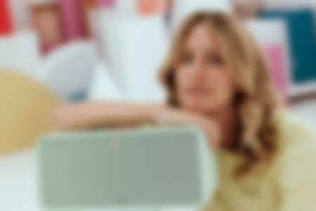 Kobieta siedzi na podłodze z zielonym głośnikiem Bluetooth BOOMSTER 4.