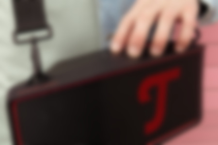 Una persona sostiene un altavoz portátil ROCKSTER CROSS 2 negro con un diseño elegante, listo para una experiencia de música al aire libre.