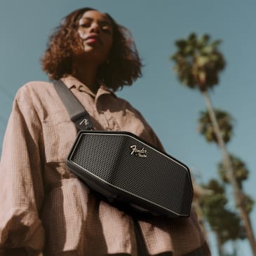 Eine Person hält einen Fender Rockster Cross 2 Lautsprecher.