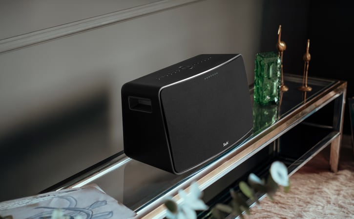 MOTIV® XL steht auf einem modernen Couchtisch neben Dekoartikeln in einem Wohnzimmer
